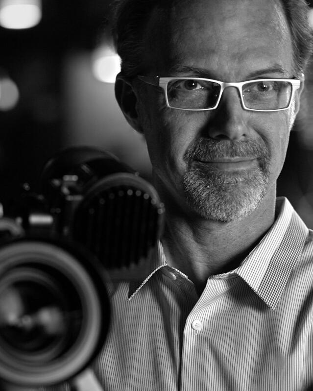 Black & White photo of cinematographer Scott Dale with ARRI camera