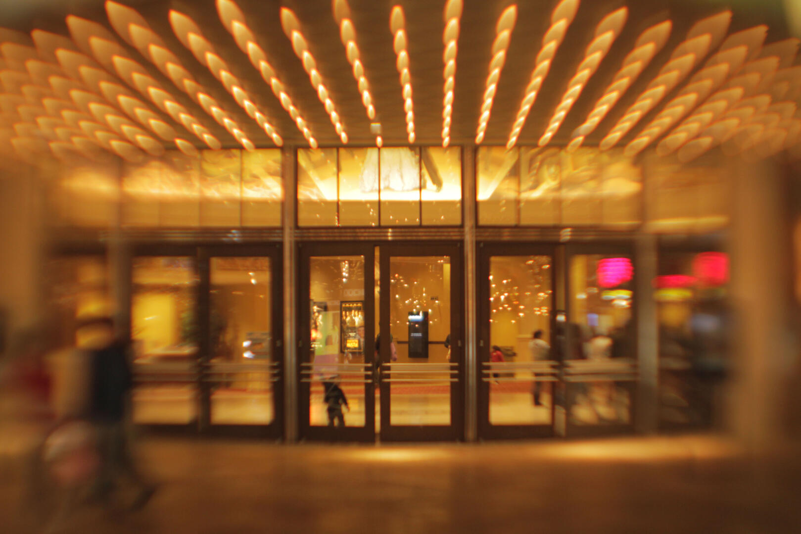 Lens attachment invention creating some astigmatism with coma - image of building entry with warm lights in awning