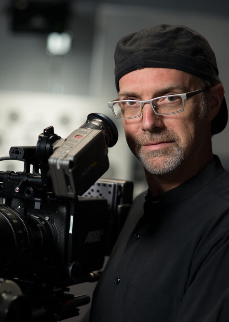 Black and white Photo of Cinematographer Scott Dale with his camera.