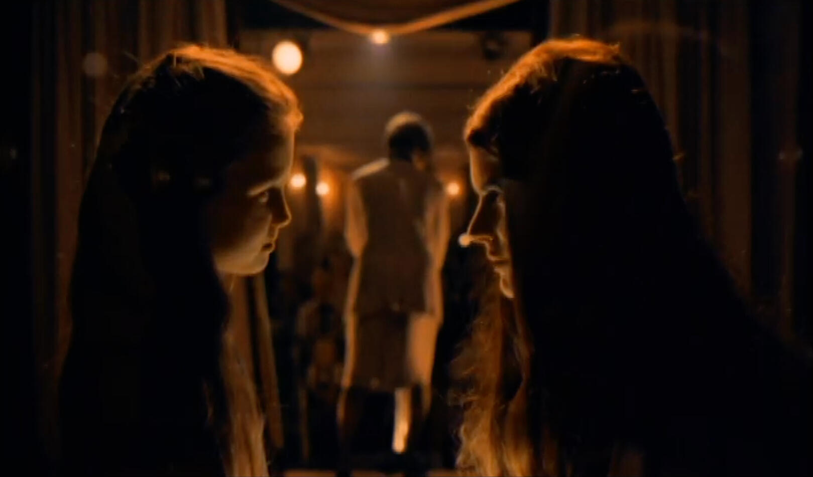 Image of 2 girls talking in amber light